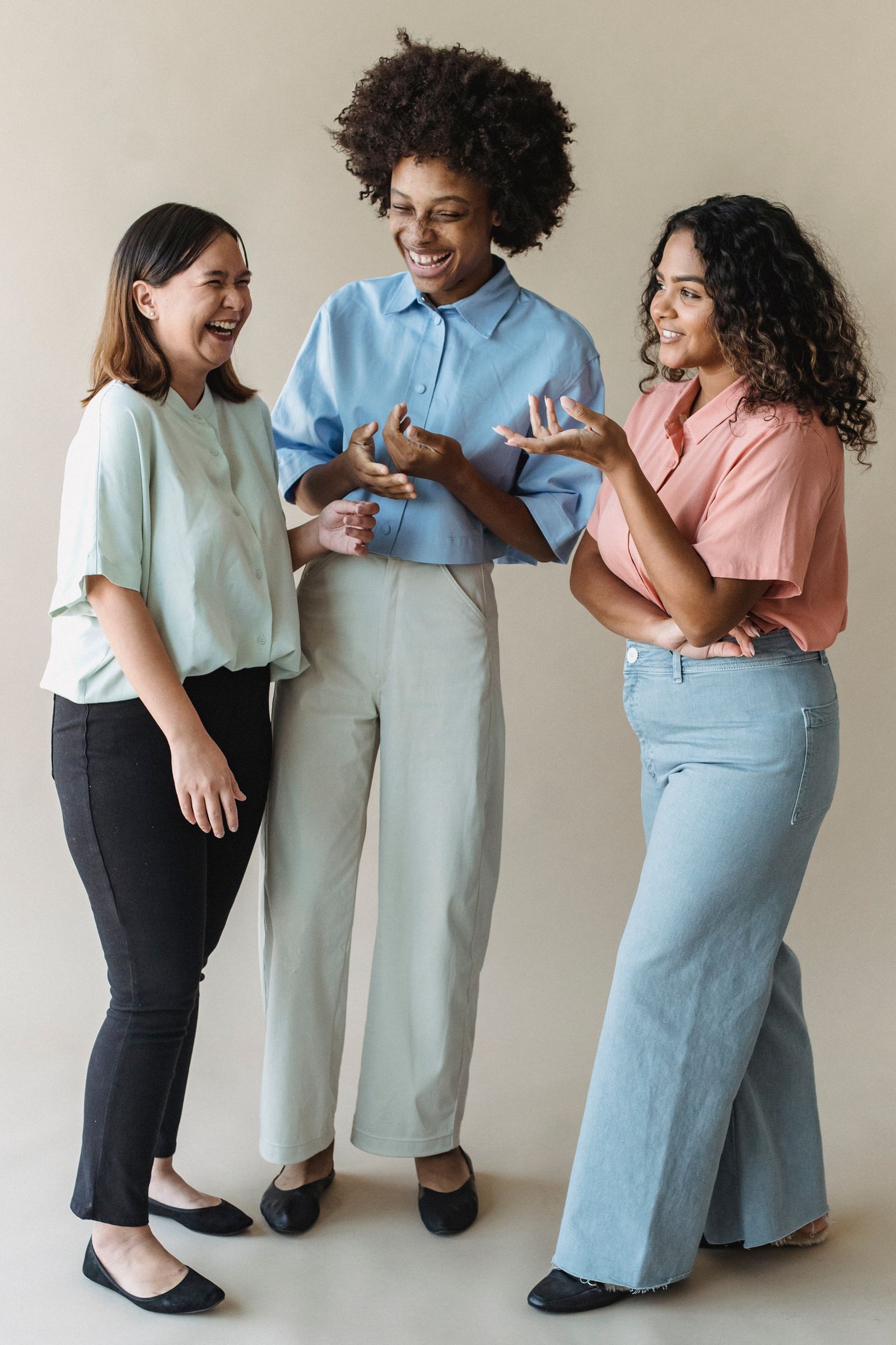 Three adult women laughing and connecting together