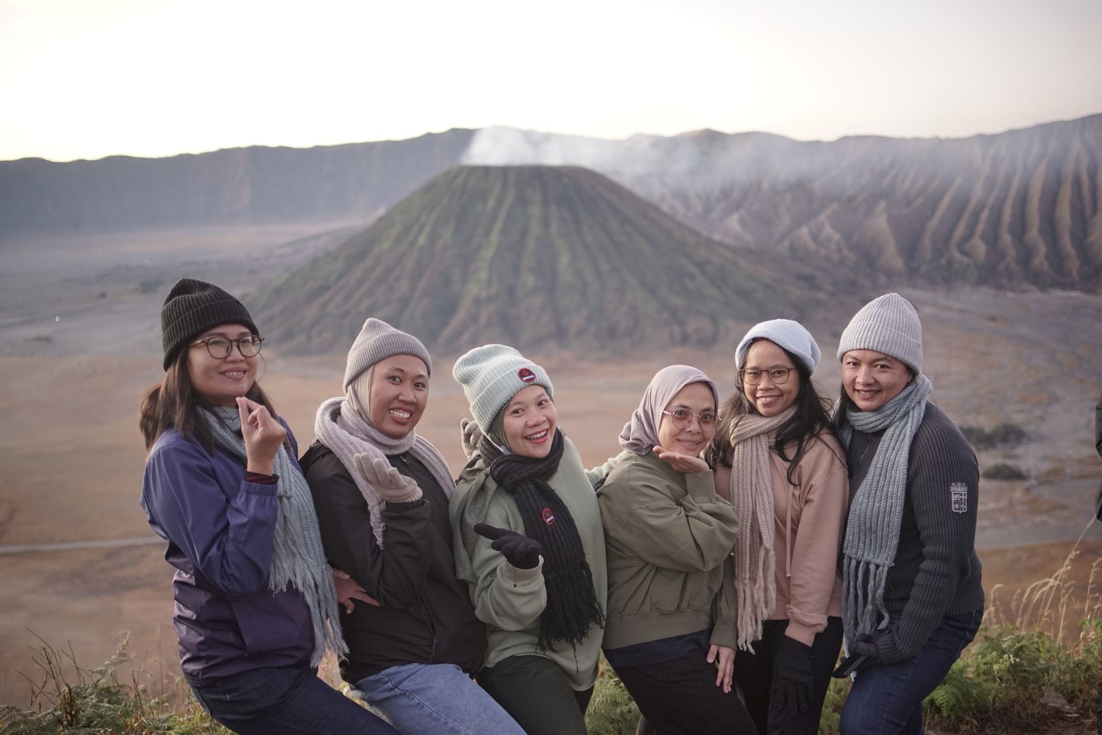 Six adult women sharing a travel moment beside a volcano